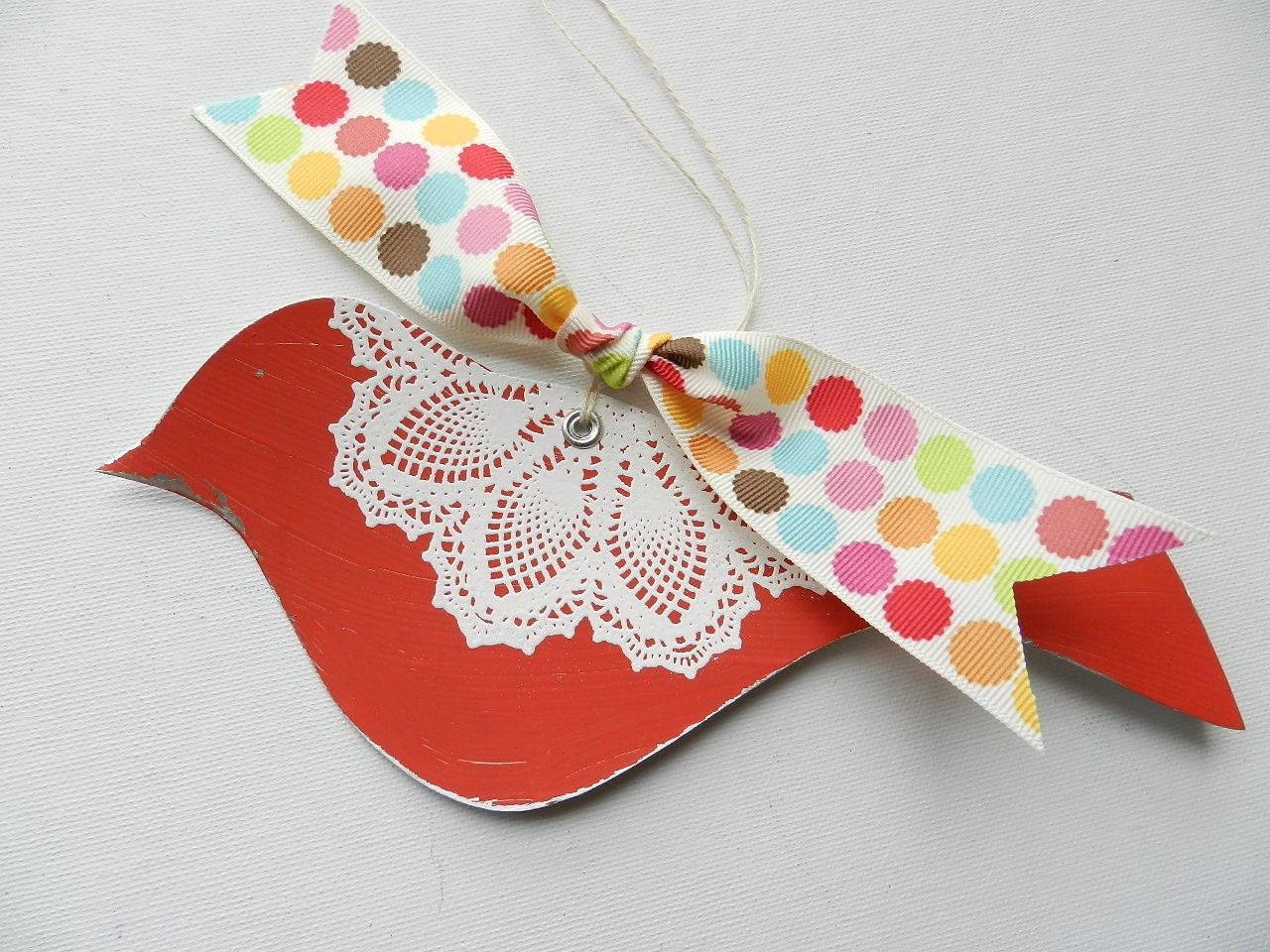 Red bird with white doily design and colorful ribbon home decor