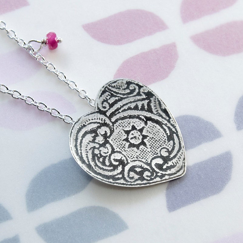 Etched heart pendant with faceted ruby