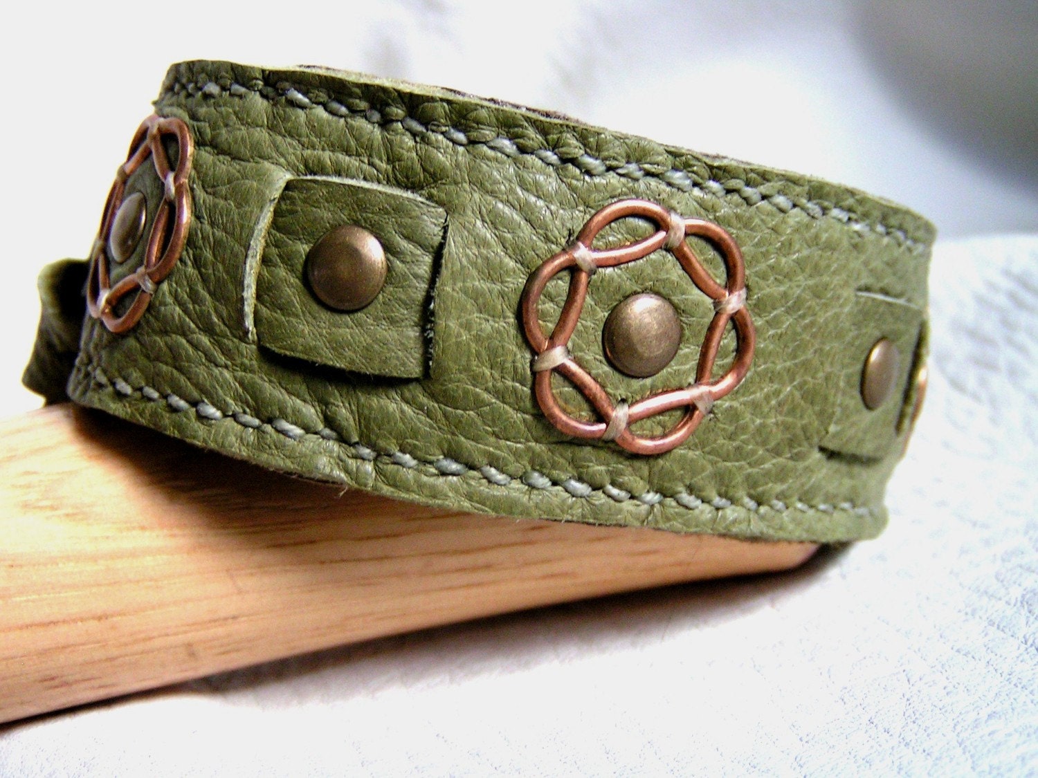 Rosettes on olive deerskin cuff