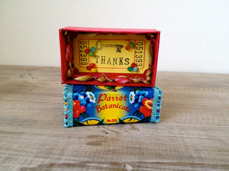 Altered vintage matchbox with a tropical bright greeting inside