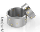 gold rivet in wide stainless band . ring