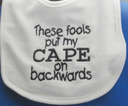 These Fools Put My Cape on Backwards Bib White Navy Letters