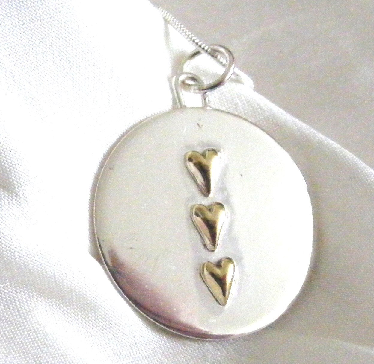 Silver Disc Pendant with 3 gold hearts