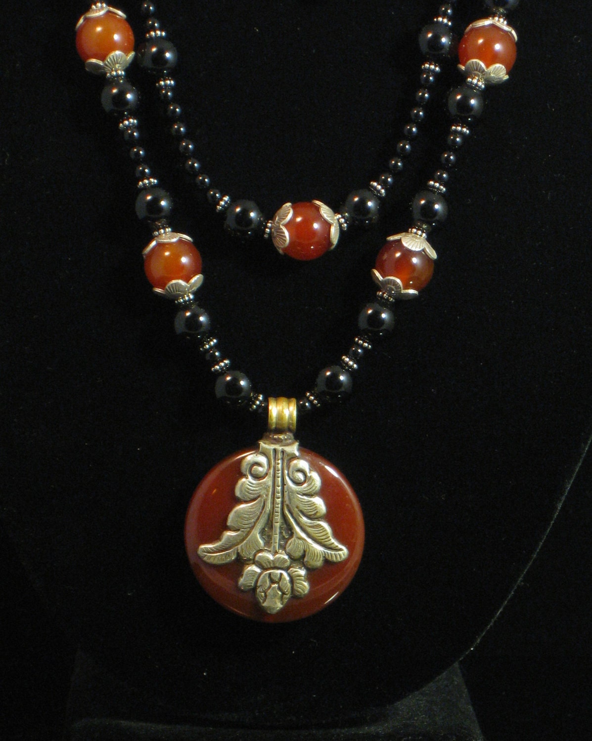 Necklace:  Double-strand with Tibetan carnelian/repousse pendant, onyx and carnelian beads