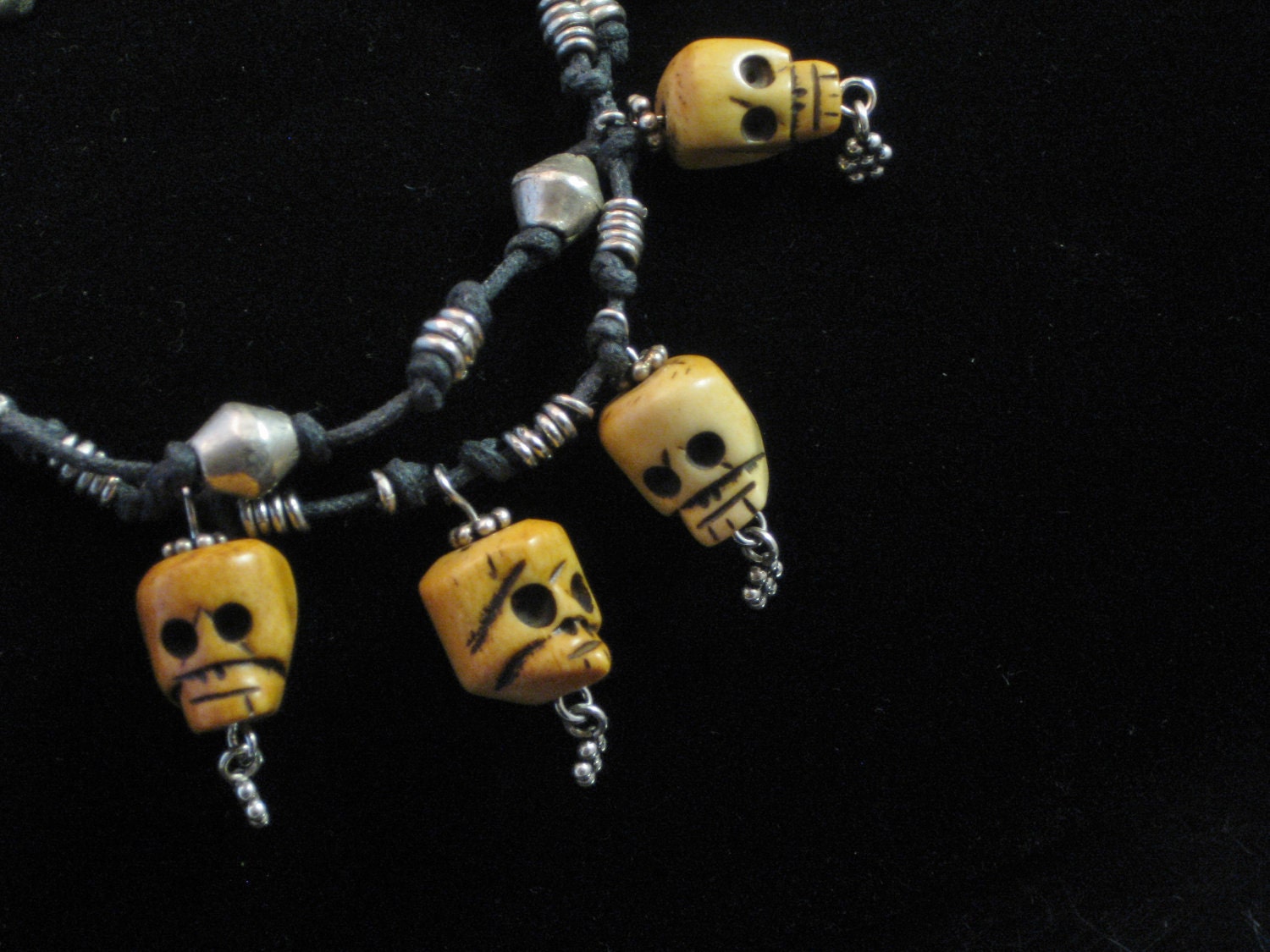 Bracelet - Carved bone skull beads and sterling charms on waxed linen chord with Ethiopian bicone and ring beads