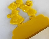 Vintage 1960s yellow notepad holder with Dutch boy and girl motif