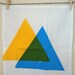 hand screen printed tea towel. blue and yellow makes green triangles.