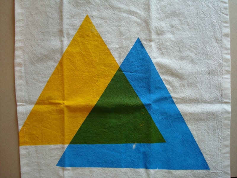 hand screen printed tea towel. blue and yellow makes green triangles.