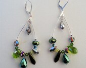 Silver elongated hoop earrings with green and silver crystals and glass beads. Very light weight and fun to wear. 2"