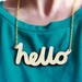 Hello Wooden Necklace. Laser cut in eco friendly birch wood. Gold or silver plated chain.