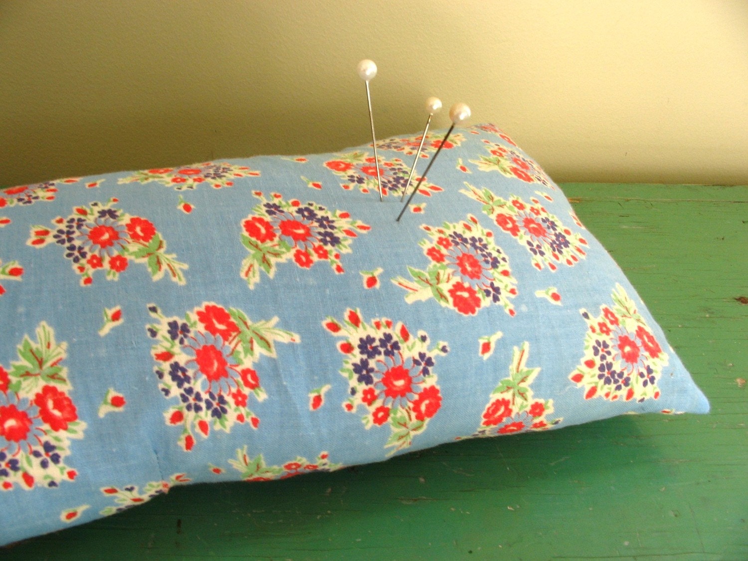 large vintage pincushion made from floral feedsack fabric