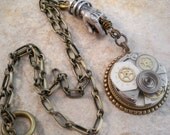 Steampunk watch movement necklace carried off by disembodied hand....
