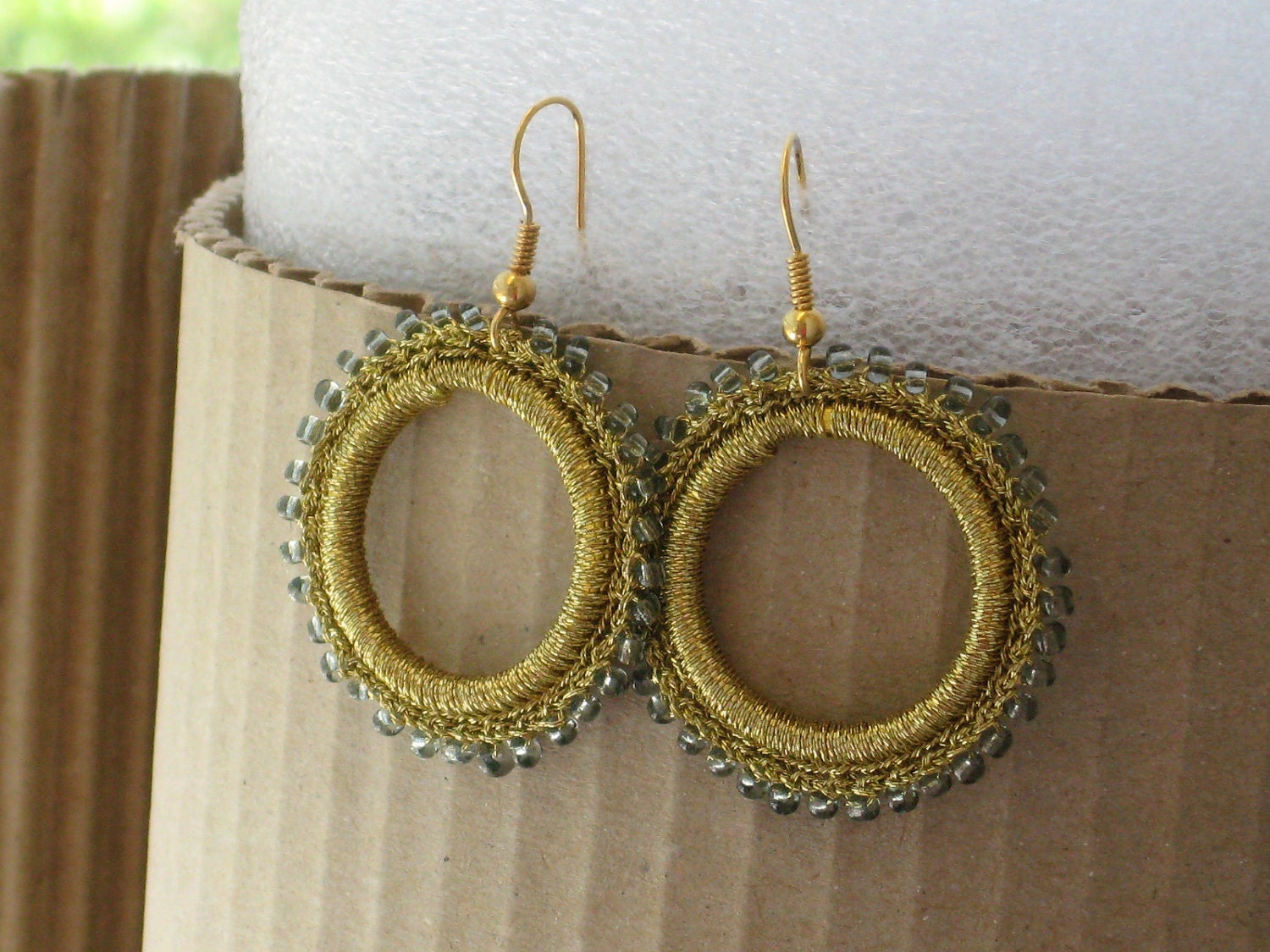 Gold crocheted hoop earrings with transparent black glass beads