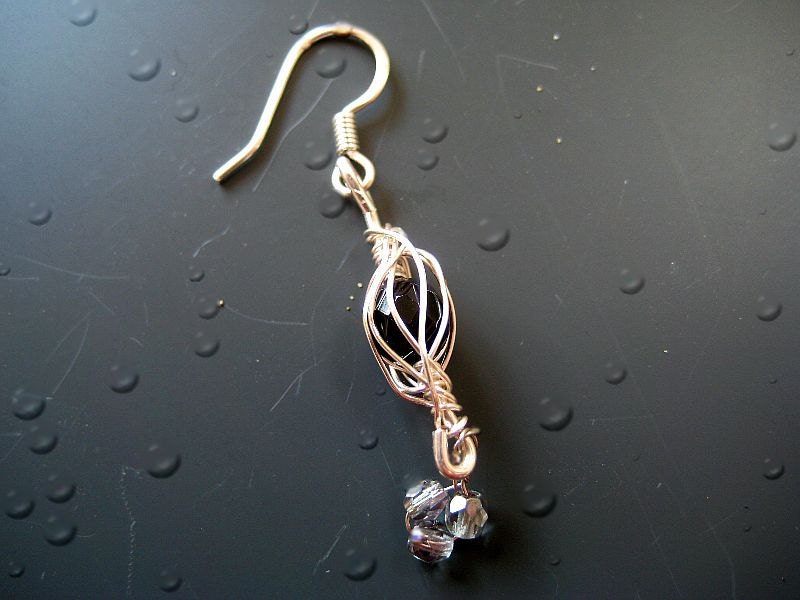 Hand crafted wire wrapped earring a  caged bead in silver and black