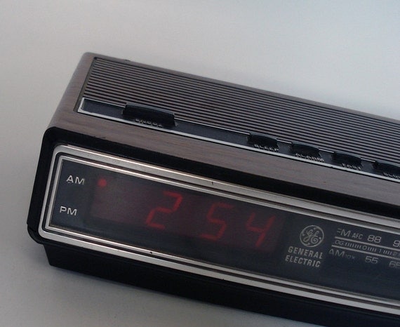 Vintage 1970s General Electric alarm clock with red digital numbers and woodgrain exterior