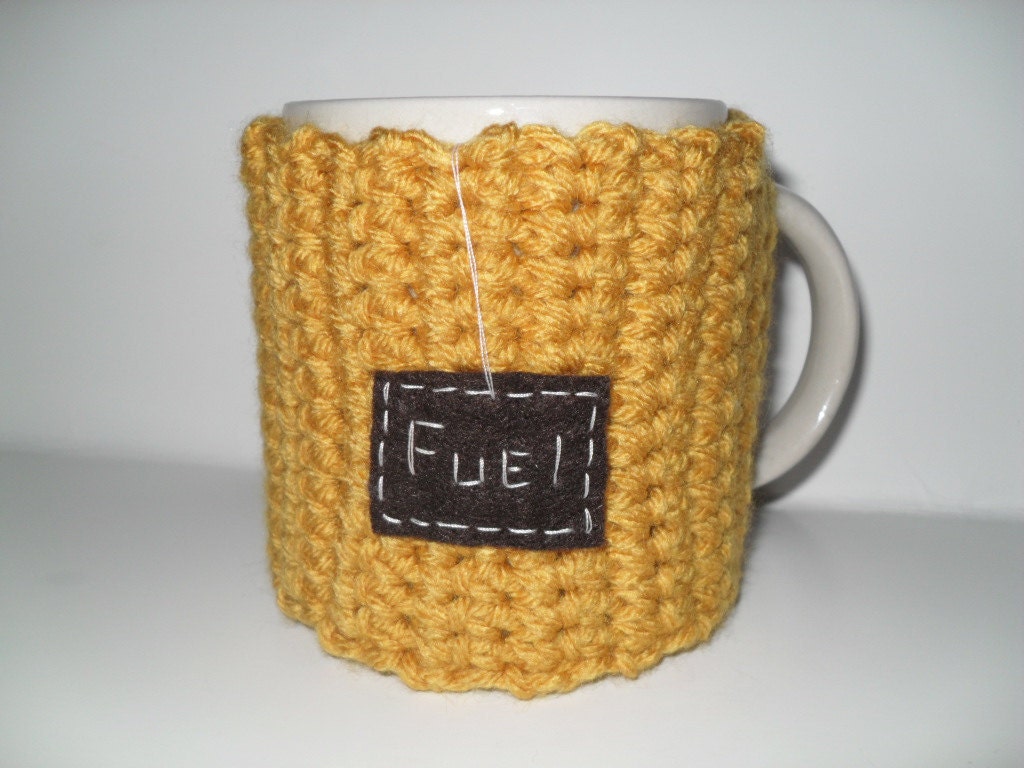 crocheted mug cozy or cup cozy in mustard gold yellow with brown fuel patch