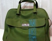 green carry on with turquoise tree