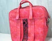 bright pink carry on with black tree