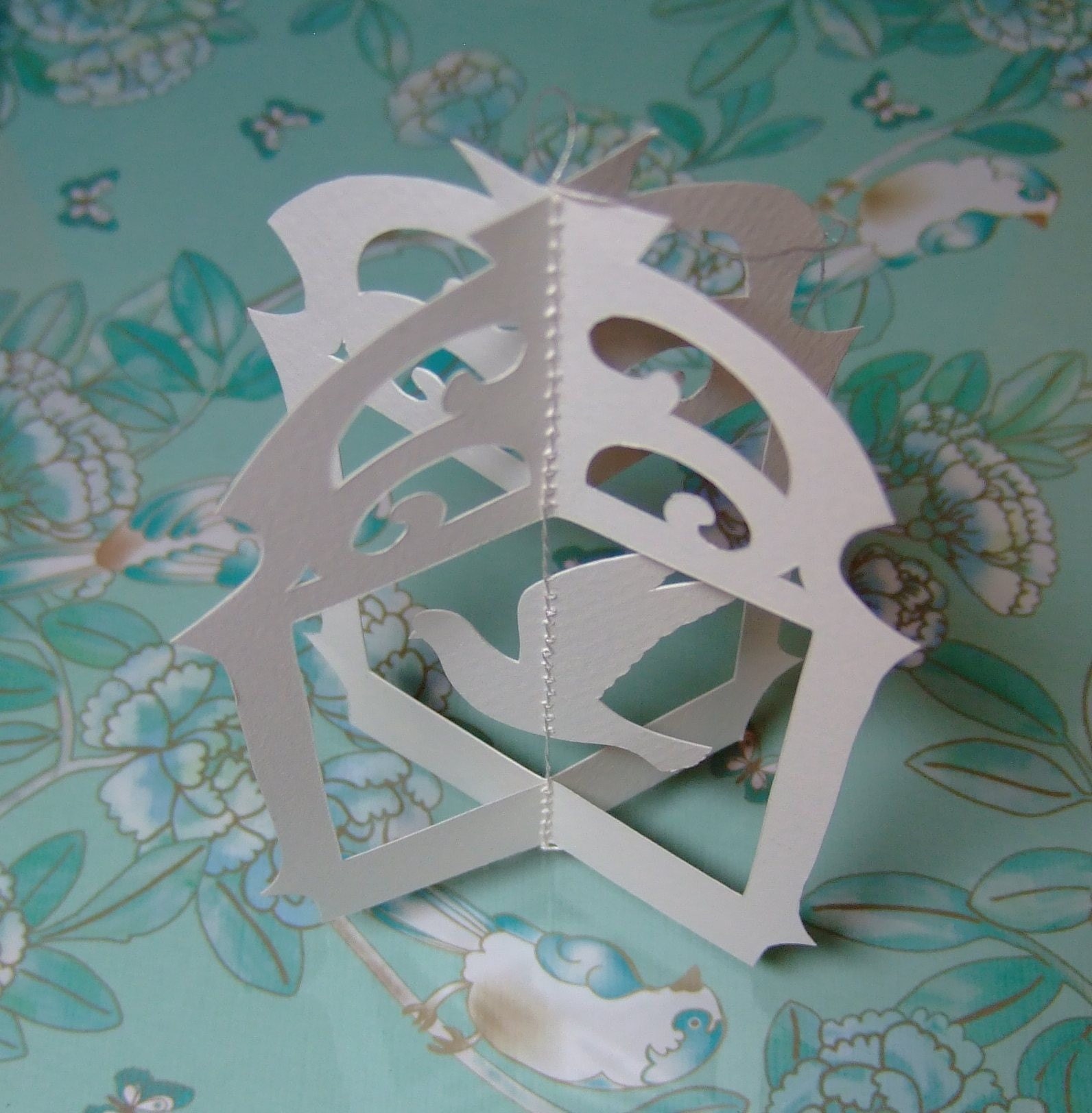 Original hand cut papercut of flying bird in cage - ivory