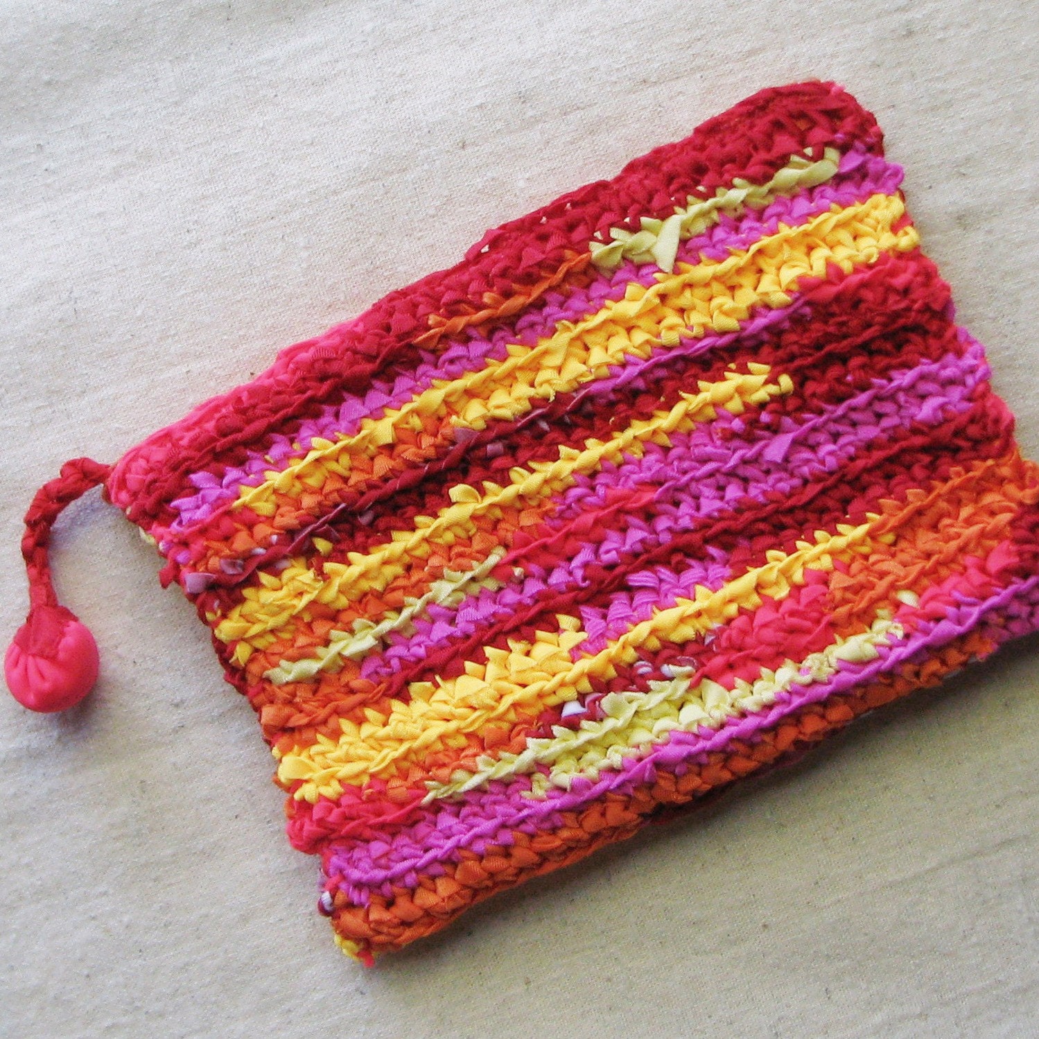 Zippered pouch crocheted in sunset stripes from colorful eco-friendly upcycled yarn, 7.5" by 5.5", red orange yellow pink coral