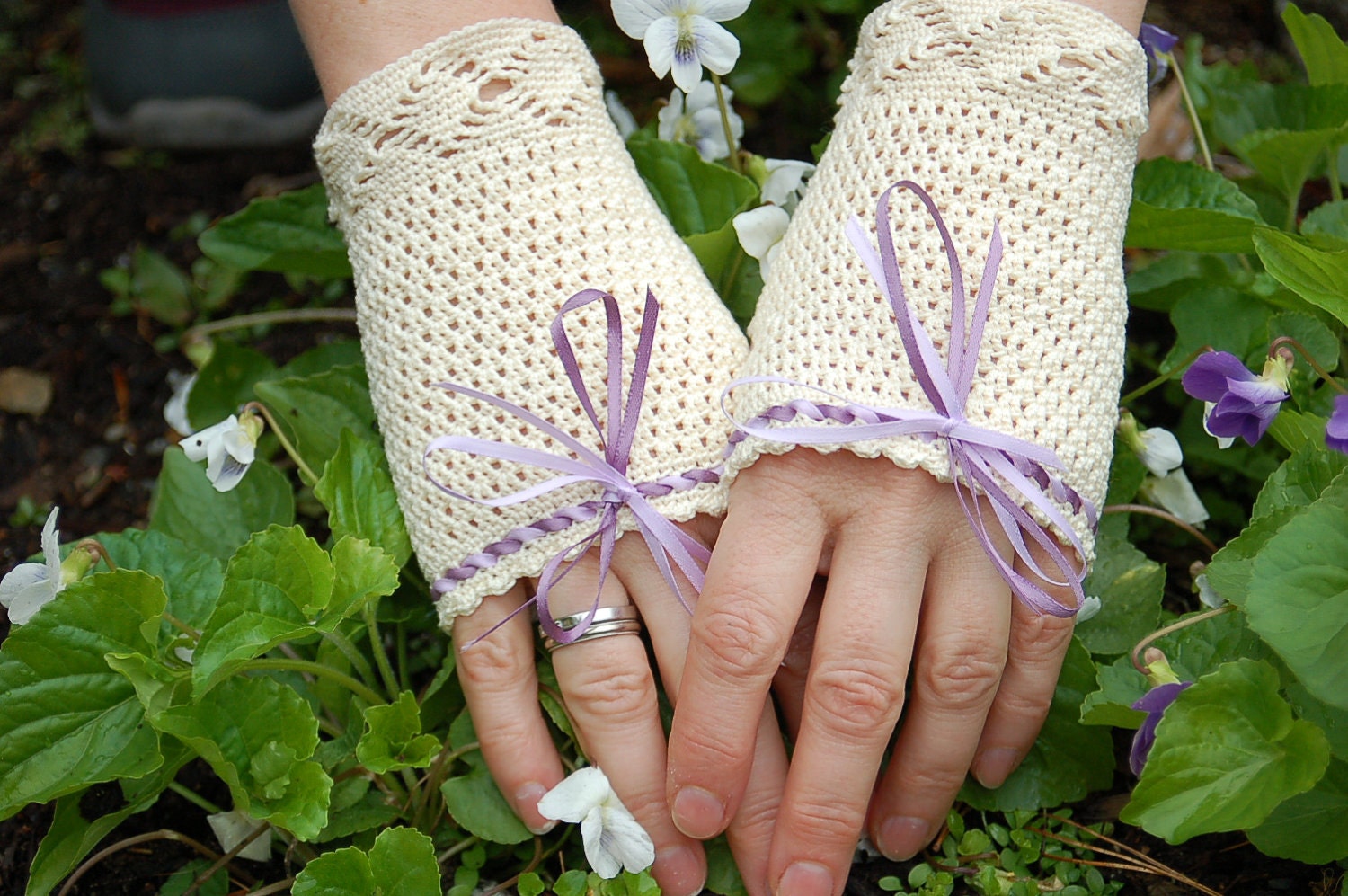 Fingerless crocheted lace gloves with purple color ribbon.