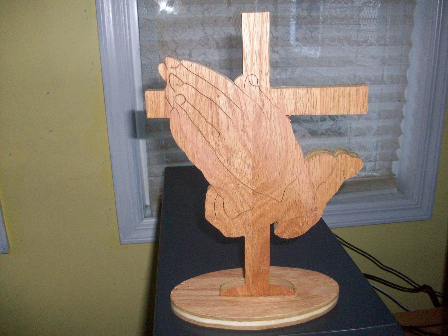 Wooden praying hands and cross display