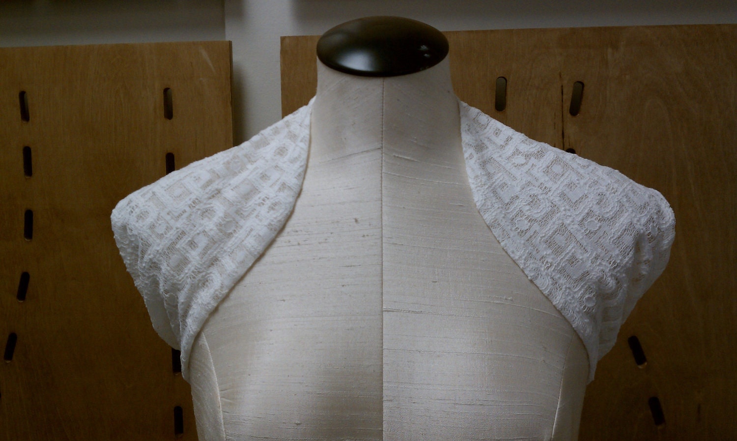 Modern geometric lace shrug with shoulder blade cutouts