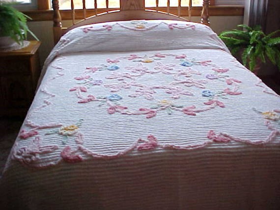 Soft pink and blue flowered Chenille bedspread on white
