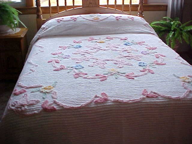 Soft pink and blue flowered Chenille bedspread on white