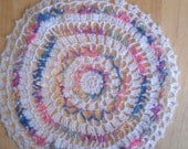 Crocheted doily of white and rainbow cotten thread