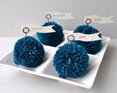 Turquoise, peacock yarn pom pom place holders.  As sold online at Anthropologie May 2013