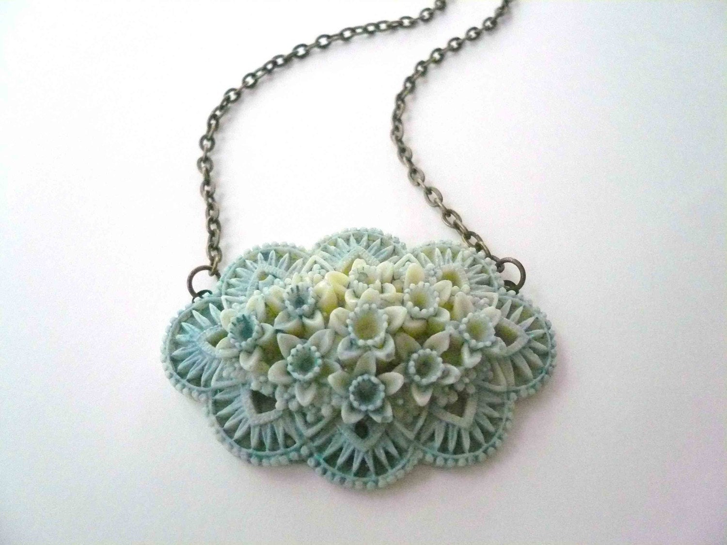 Pastel blue necklace. Blue and ivory sideways filigree flower on dark brass chain.