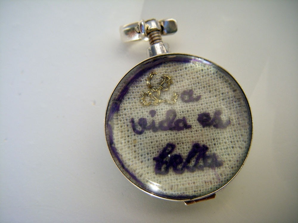 Hand embroidered  art piece 'Life is beautiful' in a two sided glass locket , Sterling Silver.