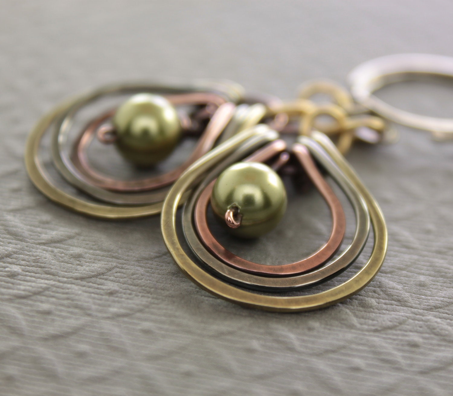 Multicolored metal earrings with copper, German silver and brass hoops with green Swarovski pearls