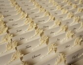 White wedding place cards with ivory feather & pearls decor