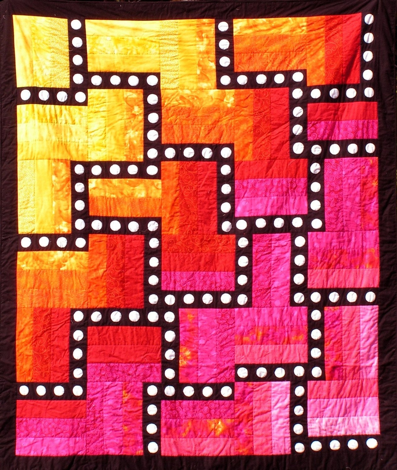 Quilt--Hot Colors of Yellow, Orange, Red and Pink Form the Background for a Black Maze with White Appliqued Circles