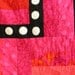 Quilt--Hot Colors of Yellow, Orange, Red and Pink Form the Background for a Black Maze with White Appliqued Circles