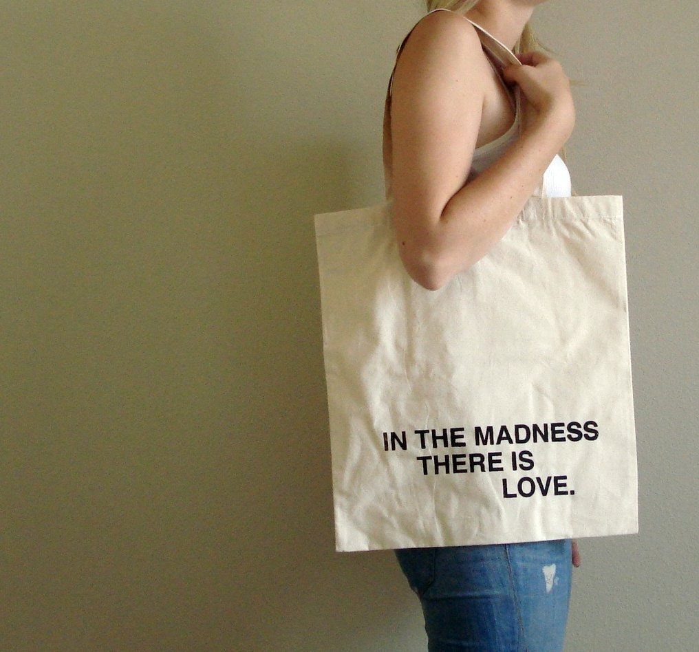 in the madness, there is love tote bag - black text