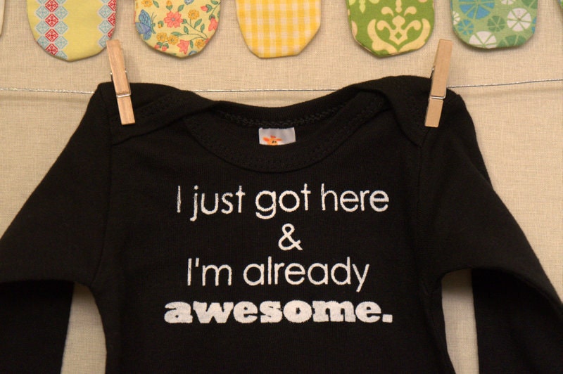 I just got here & I'm already awesome  --- black long sleeved onesie size 0-3 months.