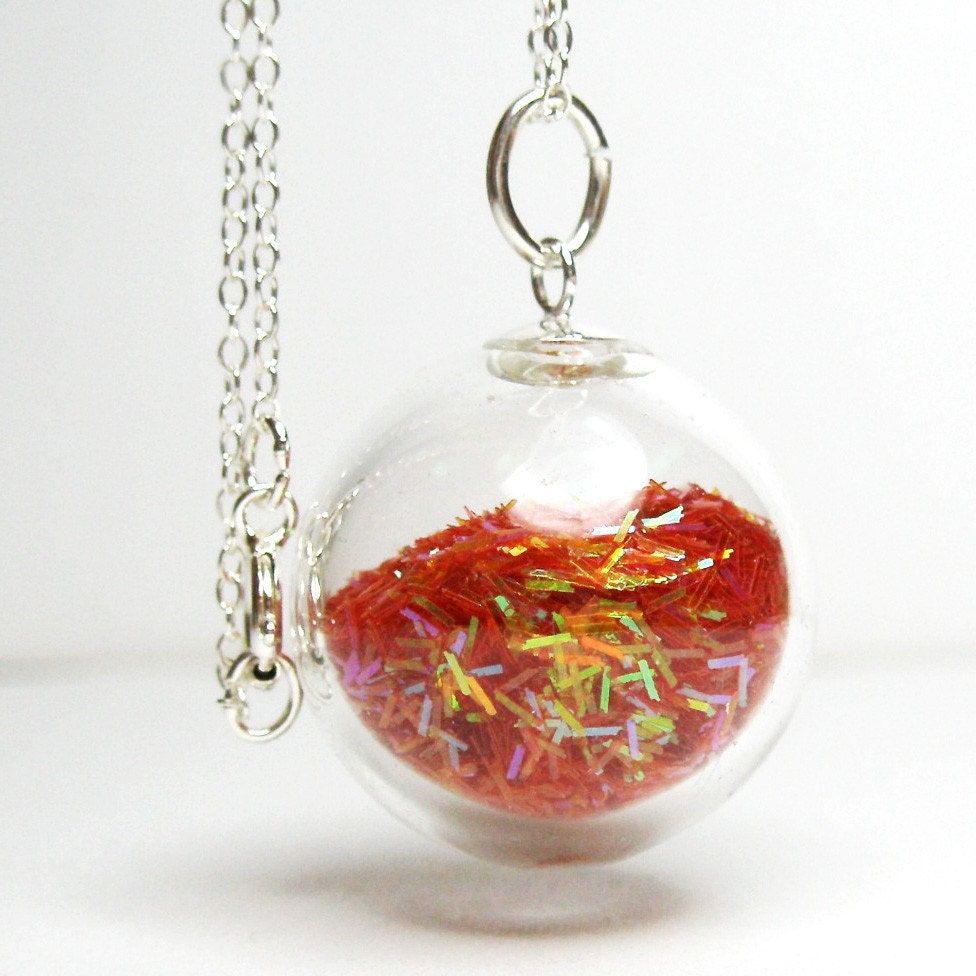 Iridescent orange tinsel glitter in round hand blown glass pendant