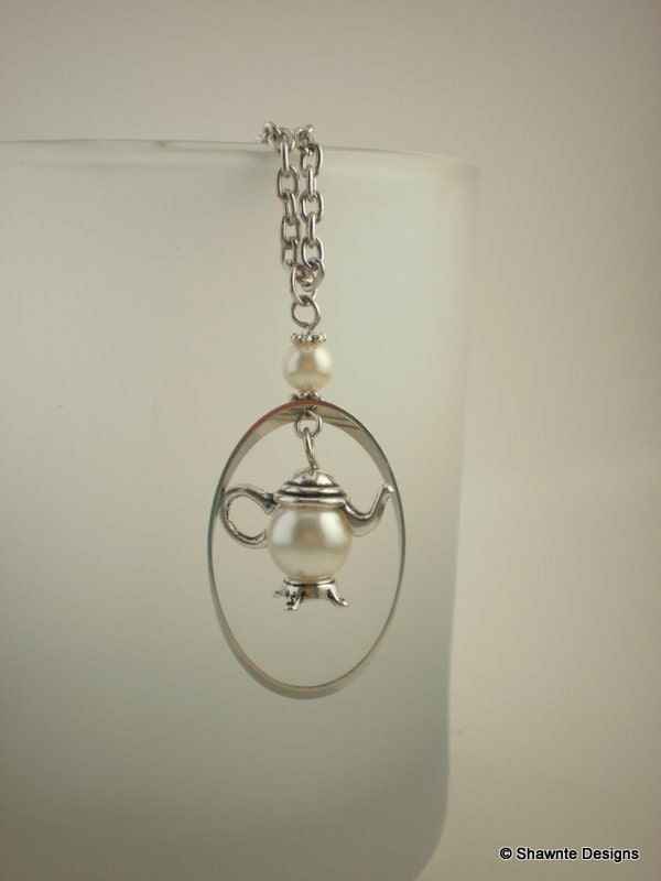 Silver teapot and pearl necklace