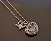 fine silver Mother bird necklace flying around the nest holding precious stones of her babies