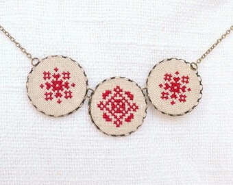 Cross stitch necklace with three royal red ornament in bronze