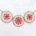 Cross stitch necklace with three royal red ornament in bronze