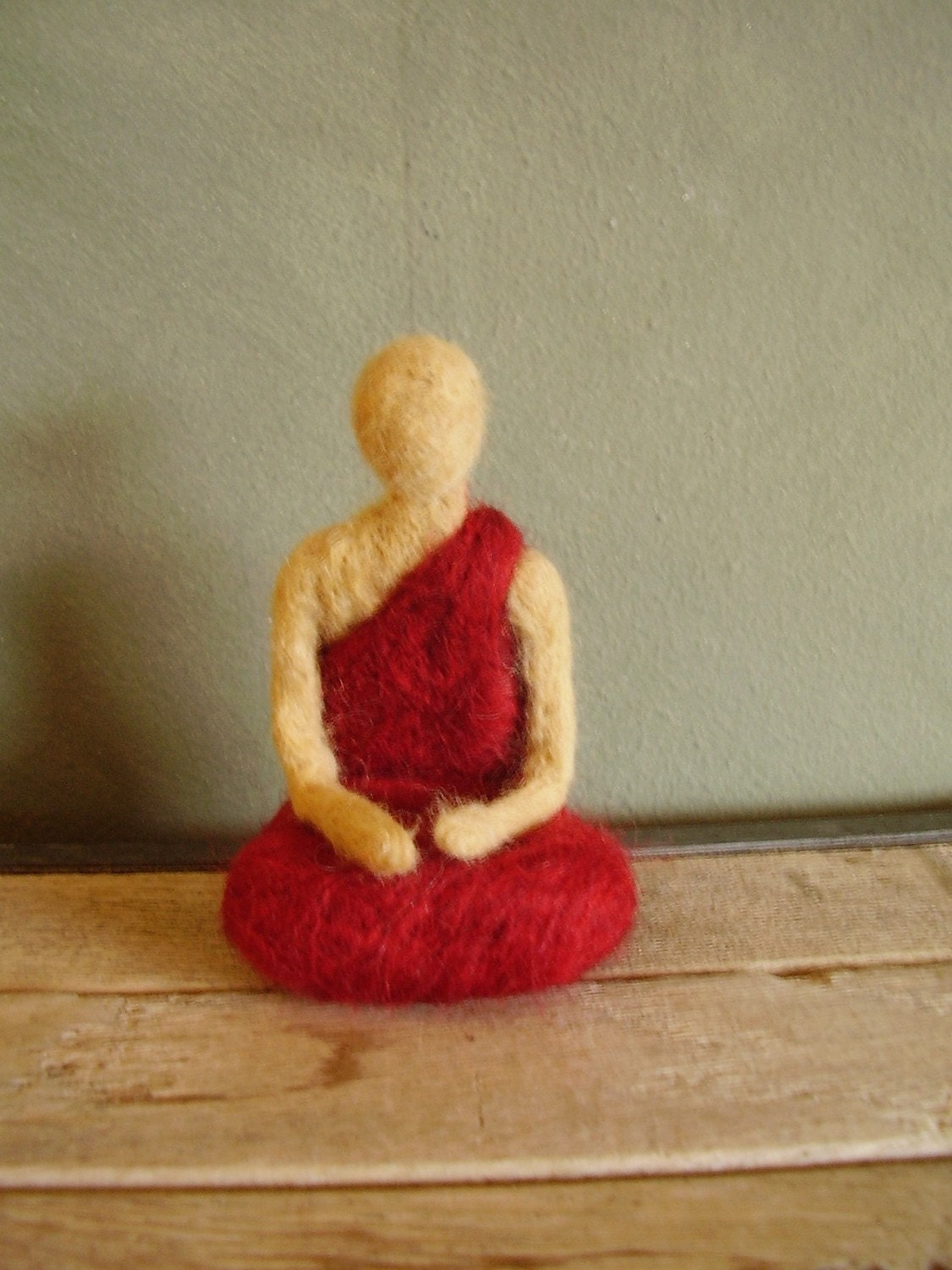 Buddhist monk in red robes, a needle-felted wool sculpture
