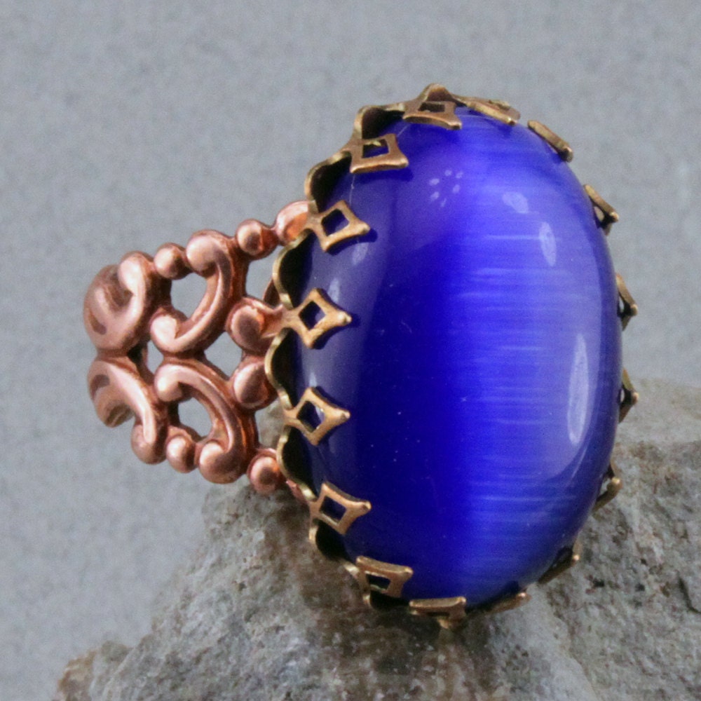 Blue Glass Cats eye ring in copper colored brass adjustable shank.
