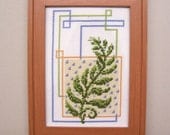 Completed Cross Stitch of Leaf and Framed with Brown Frame
