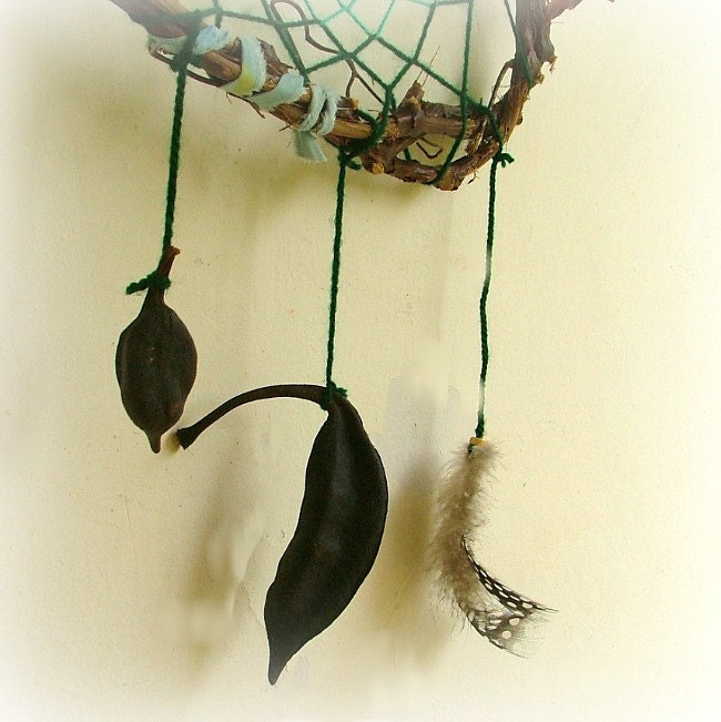 Baby mobile earth art magical dream catcher weaved in 2 shades of green with black pods and spotted feathers.