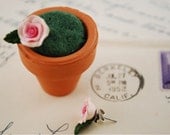 pink rose earrings in a mini clay pot