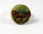 Brown Butterfly Ring on a Lime Green Fabric Backround with Teal Crystals